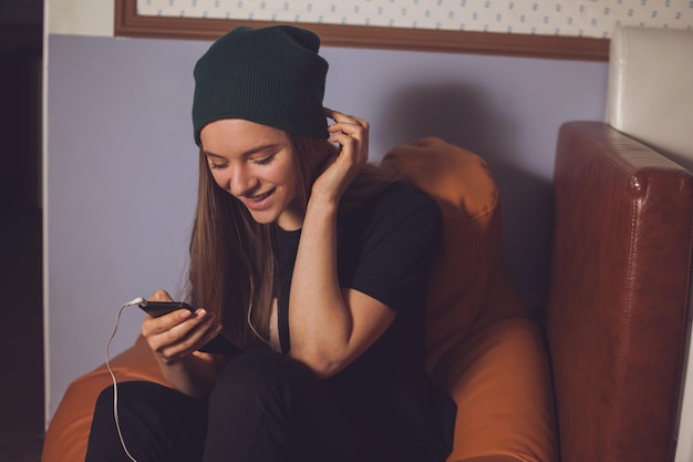 Hörende Musik des jungen netten Frauenhipsters in den Kopfhörern