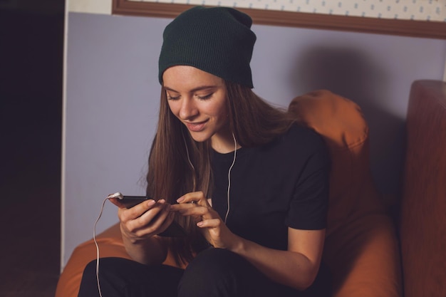 Hörende Musik des jungen netten Frauenhipsters in den Kopfhörern