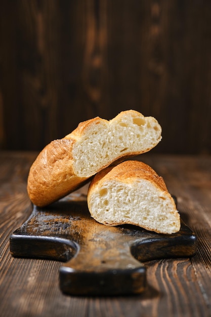 Hogaza fresca de pan de trigo en la tabla de cortar de madera