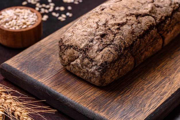 Una hogaza de pan integral con granos de cereales en una tabla para cortar madera