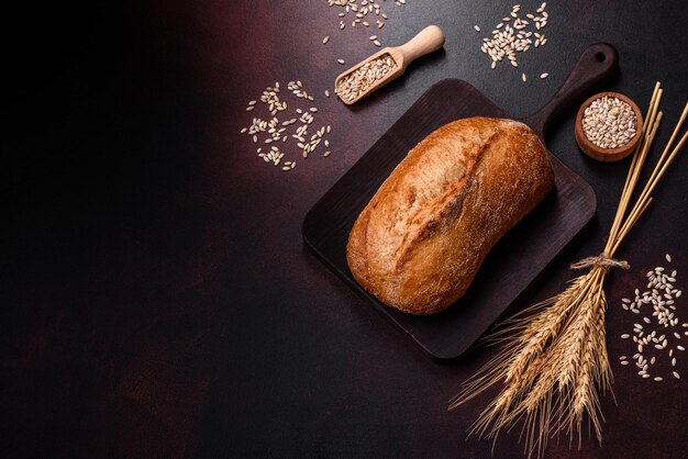 Una hogaza de pan integral con granos de cereales en una tabla para cortar madera