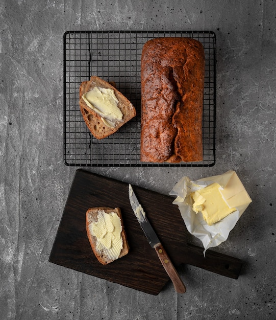 Hogaza de pan de plátano al horno casero, dos rebanadas untadas con mantequilla.