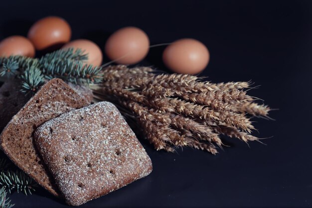 Hogazas frescas de pan con trigo y gluten en una mesa negra Concepto de panadería y abarrotes