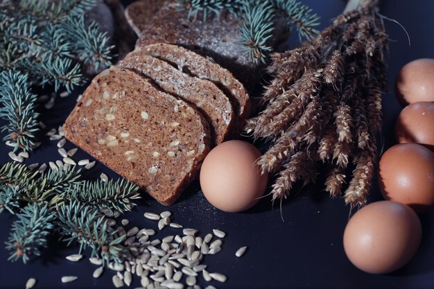 Hogazas frescas de pan con trigo y gluten en una mesa negra Concepto de panadería y abarrotes