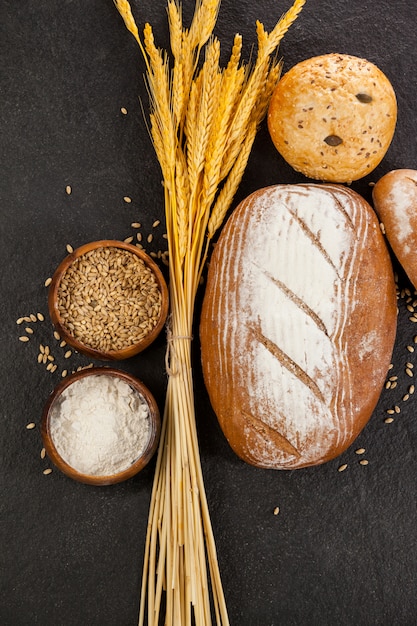 Foto hogazas de pan con granos de trigo y harina