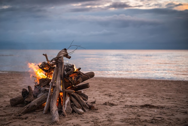 Foto hoguera en la playa con nubes dramáticas