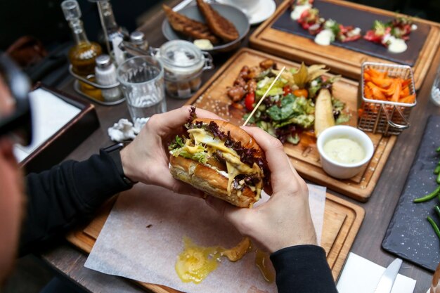 Hohe Winkelansicht der Hand, die Essen auf dem Tisch hält