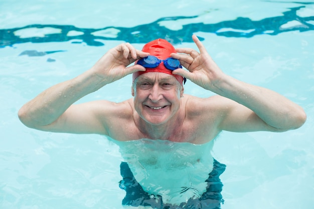 Hohe Winkelansicht des älteren Mannes, der Schutzbrille im Schwimmbad hält