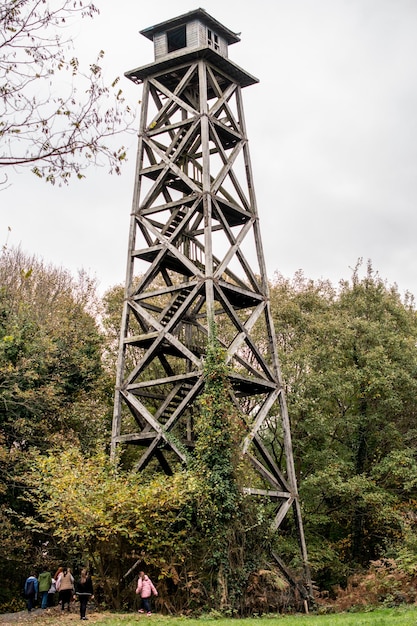 Foto hoher, verlassener holzturm zwischen bäumen