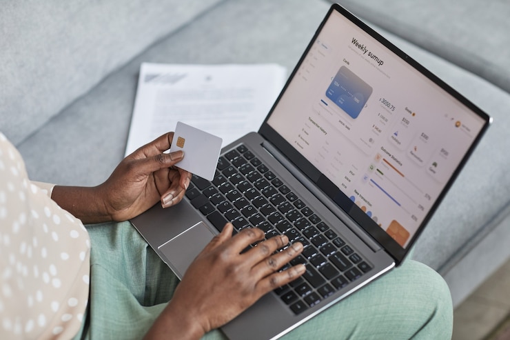 Foto hoher winkel nahaufnahme einer jungen afroamerikanischen frau mit laptop mit online-banking-service auf dem bildschirm, kopienraum