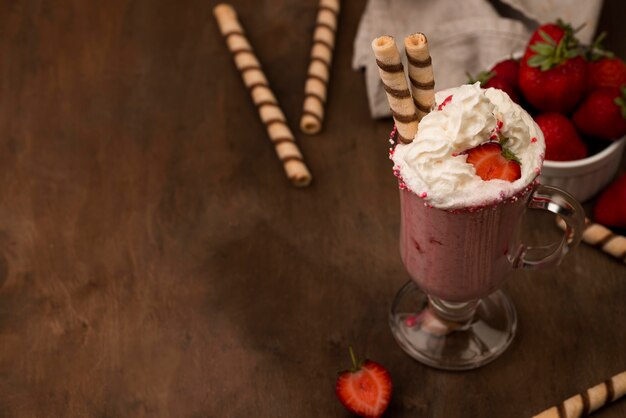 Foto hoher winkel von erdbeermilchshake mit sahne und kopierraum