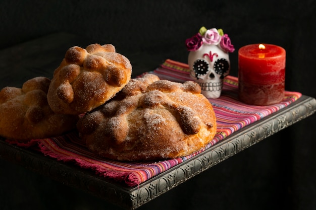 Foto hoher winkel von pan de muerto mit kerze und totenkopf