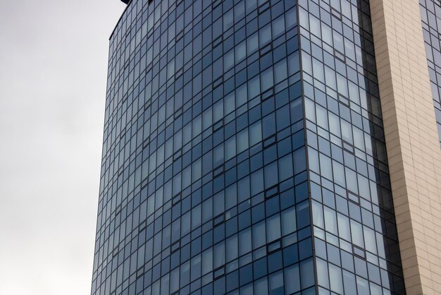 Hohes modernes Glasgebäude gegen einen grauen Himmel