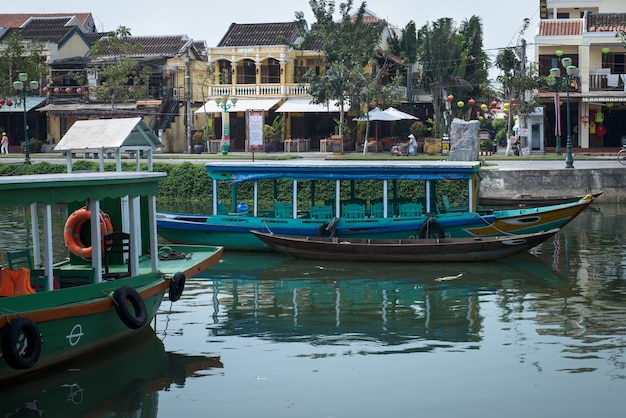 Hoian, Vietnam - 05 de abril de 2016: Barcos de madera en el río en la ciudad de Hoian en Vietnam es un destino turístico popular y sitio del patrimonio mundial de la UNESCO