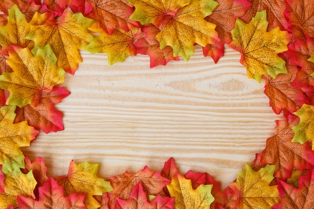 Hoja de arce y espacio libre para texto con fondo de madera.