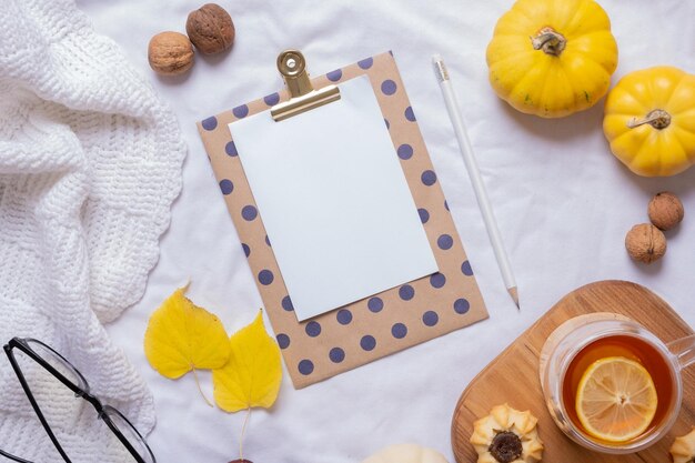 Hoja en blanco de papel y decoración acogedora de otoño y vista superior de la taza de té Espacio de copia para el texto de otoño