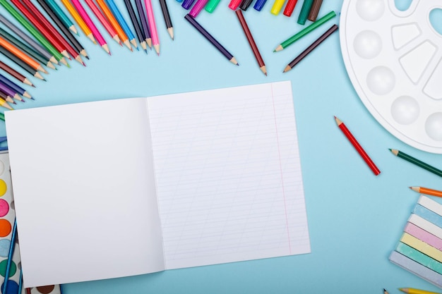 Hoja en blanco de útiles escolares de arte de cuaderno de línea oblicua para pintar sobre un fondo azul