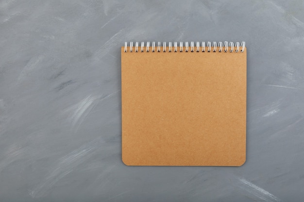 Hoja de cartón de cuaderno espiral en blanco, marrón sobre gris