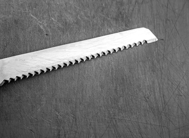 Hoja de cuchillo de metal con dientes grunge Cuchillo de acero viejo Concepto de cocina duro cuchillo negro rígido