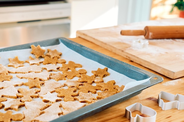 Foto hoja de hornear con galletas de pan de jengibre de navidad una forma de hombre de pan de jengibre árbol de navidad y estrella