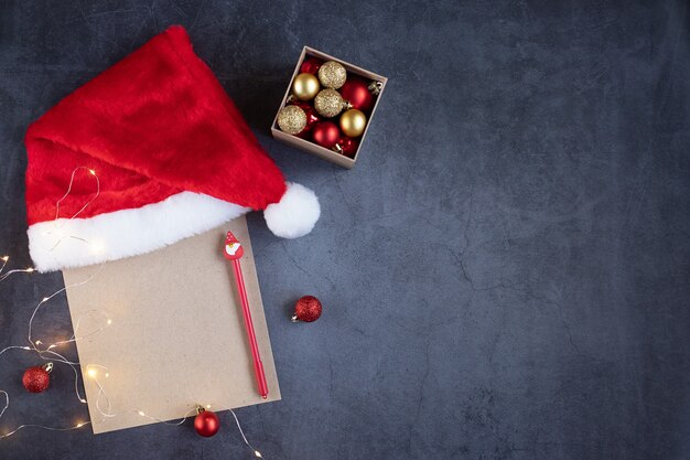 Hoja de manualidades para escribir a Papá Noel estilizada con un gorro navideño de bolas de luces y un bolígrafo con Papá Noel