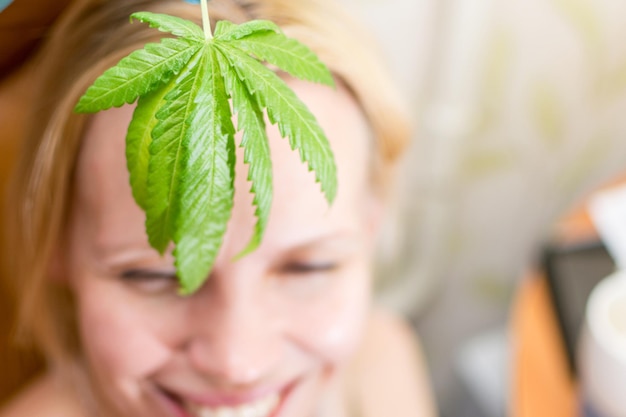 Foto una hoja de marihuana en el fondo de una cabeza femenina