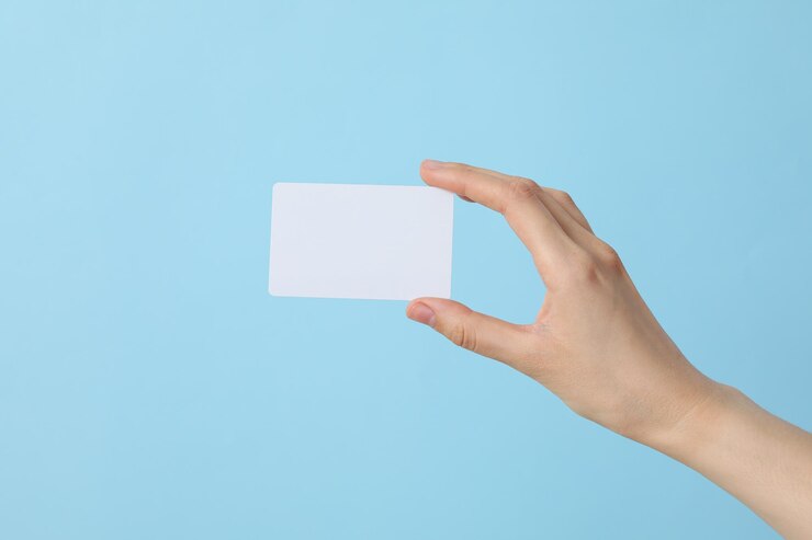Una hoja de papel blanca en manos de una mujer de fondo azul