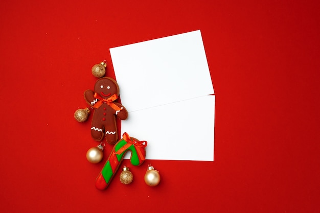 Foto hoja de papel en blanco con galletas de jengibre sobre fondo rojo.