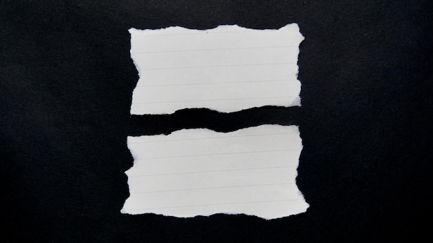 Hoja de papel blanco rasgada aislada sobre un fondo negro