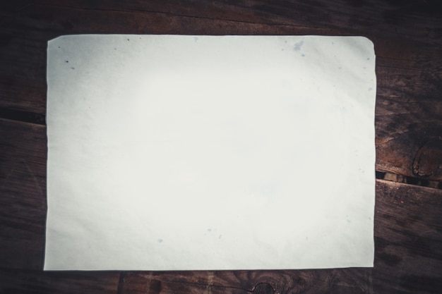 Hoja de papel blanco sobre una superficie de madera. Trozo de papel en blanco sobre una superficie de madera. Telón de fondo de base de base abstracta. Espacio para texto