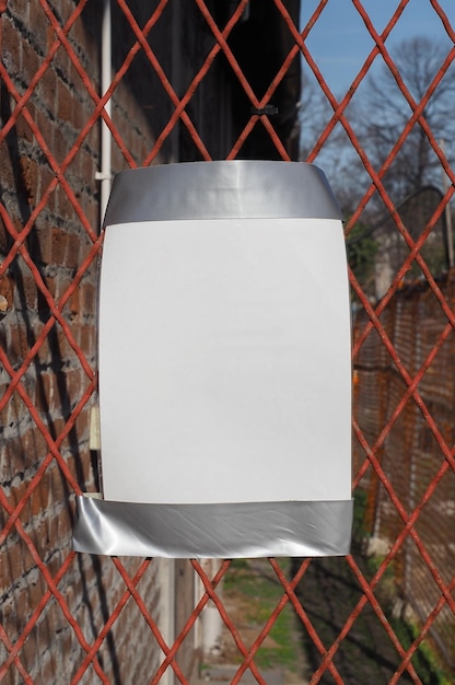 Foto hoja de papel en blanco en una valla