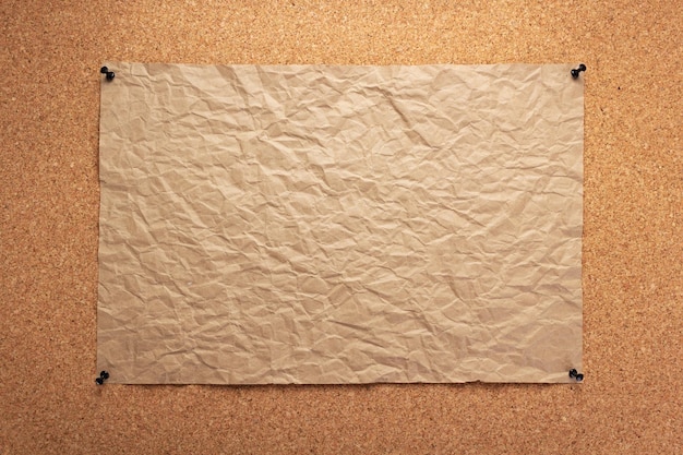 Hoja de papel fijada en panel de corcho como fondo