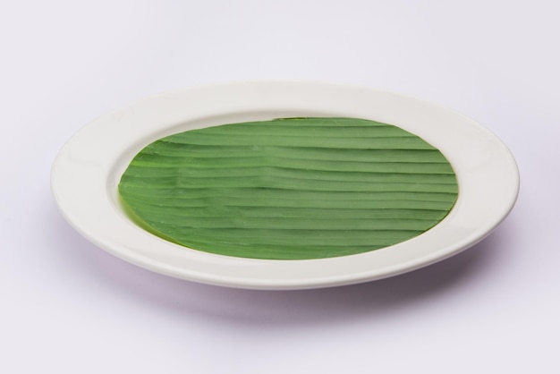 Hoja de plátano en un plato en blanco para editar comida o tema en