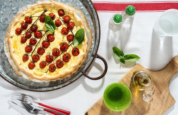 Hojaldre italiano de verano con tomates cherry y ricotta sobre un mantel blanco