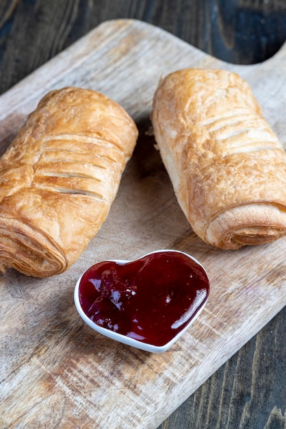 Hojaldre con mermelada de fresa roja sobre una mesa de madera