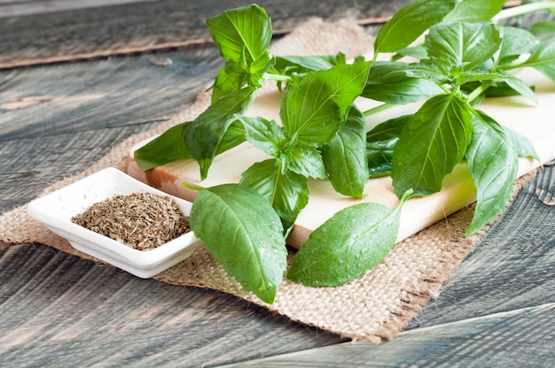 Hojas de albahaca fresca y seca sobre un fondo de madera vieja