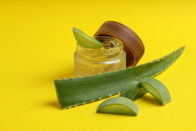 Hojas de aloe y gel sobre fondo amarillo