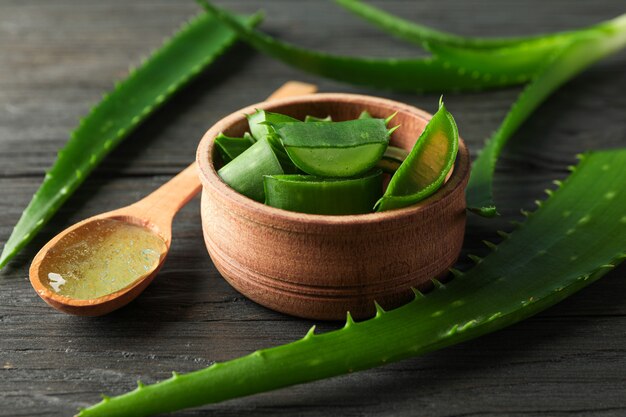 Hojas de aloe vera y rodajas en la mesa de madera