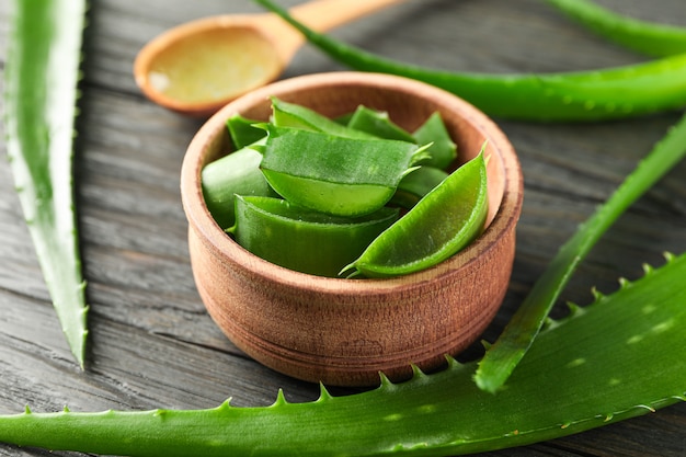 Hojas de aloe vera y rodajas en la mesa de madera