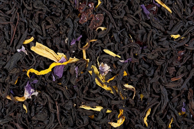 Hojas aromáticas de té negro con pétalos de girasol y aciano