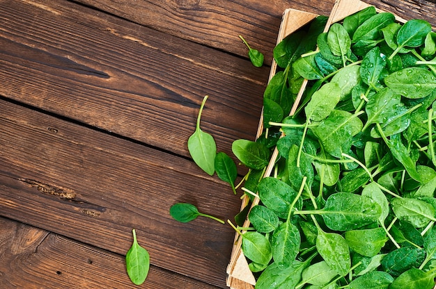 Hojas de espinaca fresca en un fondo de madera