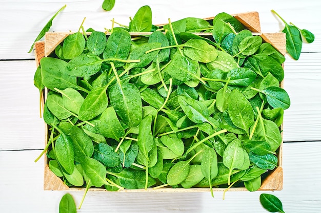 Hojas de espinaca fresca en un fondo de madera