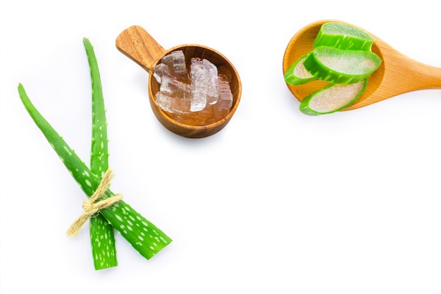 Hojas frescas de aloe vera con gel de aloe vera en cuchara de madera.