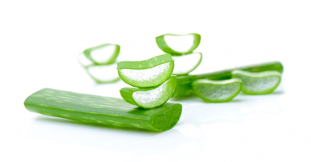 Hojas frescas de aloe vera en la pared blanca