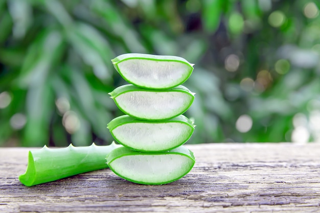 Foto hojas frescas de aloe vera y rodajas en la mesa de madera para productos de salud.