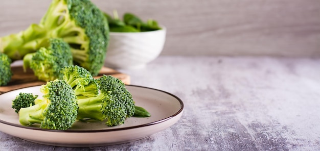 Hojas frescas de brócoli y espinacas en un plato sobre la mesa Comida saludable Comida verde Banner web