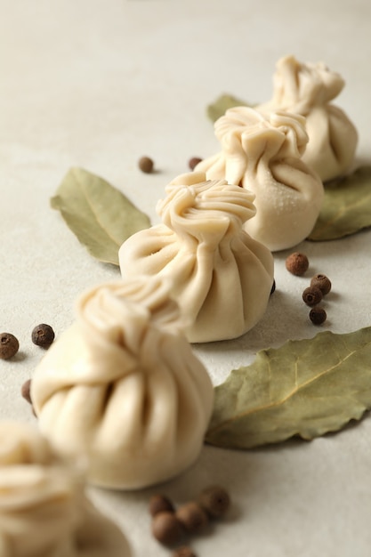 Hojas de khinkali, pimienta y laurel crudas en blanco con textura