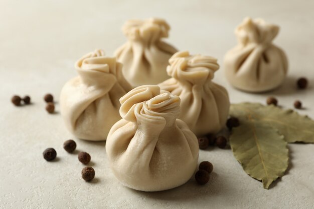 Hojas de khinkali, pimienta y laurel crudas en blanco con textura