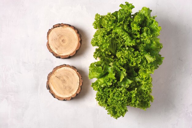 Hojas de lechuga fresca en una caja de madera sobre un gris