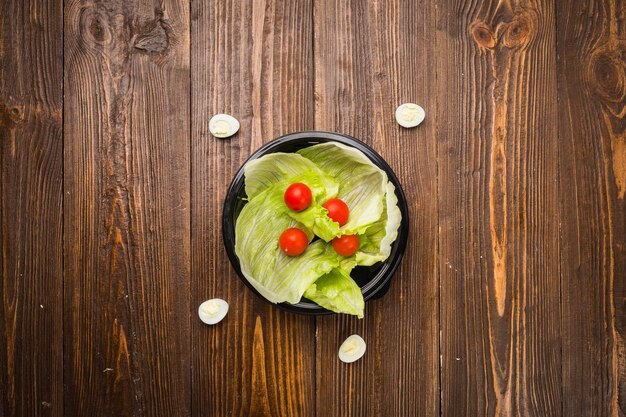 Hojas de lechuga con tomates cherry y huevos de codorniz en un plato